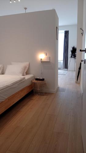 sypialnia z łóżkiem i lampką na drewnianej podłodze w obiekcie ApartmentJacob1 w Antwerpii