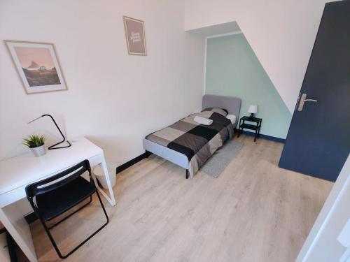 une chambre avec un lit et un bureau dans une pièce dans l'établissement Maison Lilloise 6 personnes cœur de Roubaix, à Roubaix