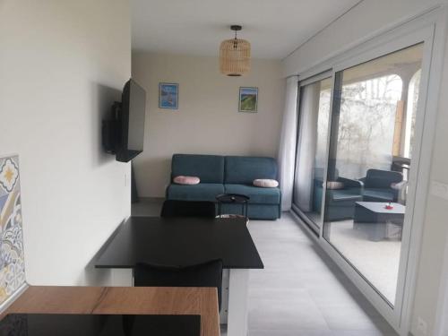 een woonkamer met een blauwe bank en een tafel bij Charmant studio au calme in Thonon-les-Bains