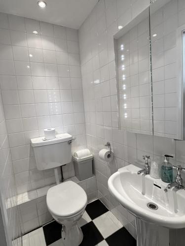 a white bathroom with a toilet and a sink at Rosehall Hotel in Edinburgh