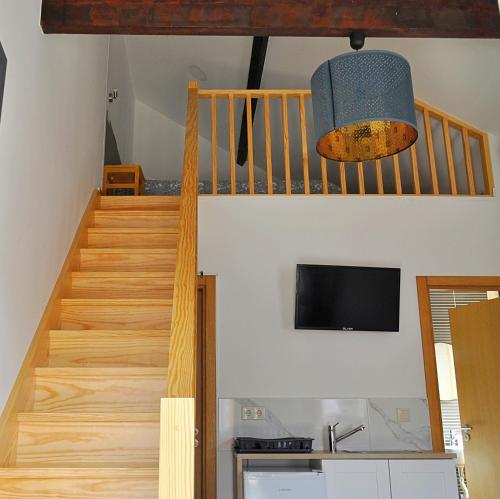Habitación con escalera y TV. en Alboi Loft, en Aveiro