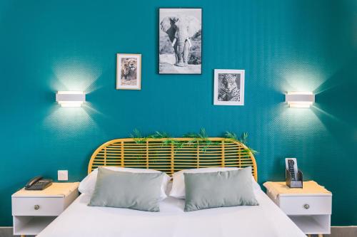 une chambre avec un lit aux murs bleus et deux lampes dans l'établissement LOGIS Hôtel & Restaurant Le Soleil D'or, à Montigny-la-Resle