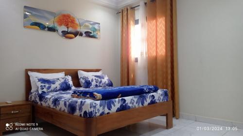 1 dormitorio con cama con sábanas azules y ventana en Chez Mamanta Studio meublé à St louis, en Saint-Louis
