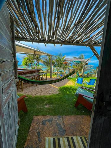 a patio with a hammock and a table and chairs at ASAS DEL MAR - SUITES in Canoa Quebrada
