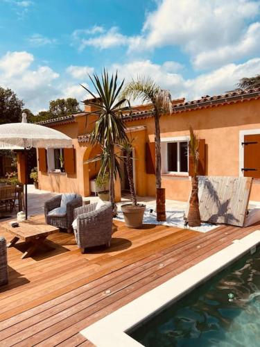 une maison avec une terrasse en bois et une piscine dans l'établissement Valbonne, villa avec piscine, à Valbonne
