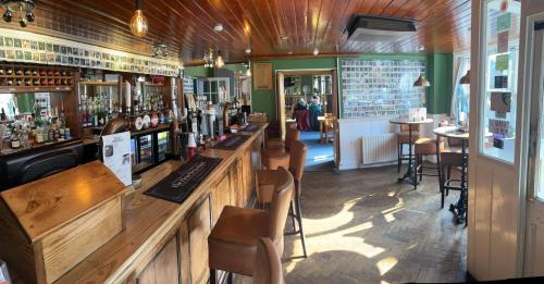 a bar in a restaurant with a counter and chairs at The Fleur De Lis in Sandwich