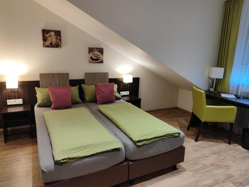 ein Schlafzimmer mit einem Bett mit einem Schreibtisch und einem gelben Stuhl in der Unterkunft Hotel Gästehaus Stock Zimmer Kaffeesäckle in Friedrichshafen