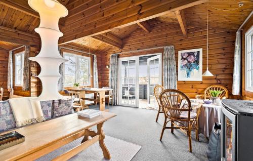 a living room with a table and chairs in a cabin at 3 Bedroom Amazing Home In Ringkøbing in Ringkøbing