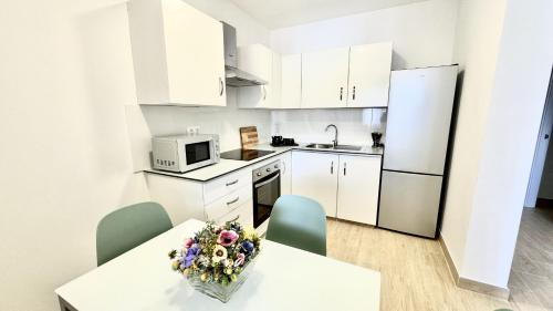 a kitchen with white cabinets and a table with flowers on it at Vilaflor Naturaleza y Relax by Deihu Experiences in Vilaflor
