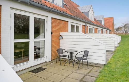 a patio with chairs and a table in front of a house at 2 Bedroom Nice Apartment In Lemvig in Lemvig