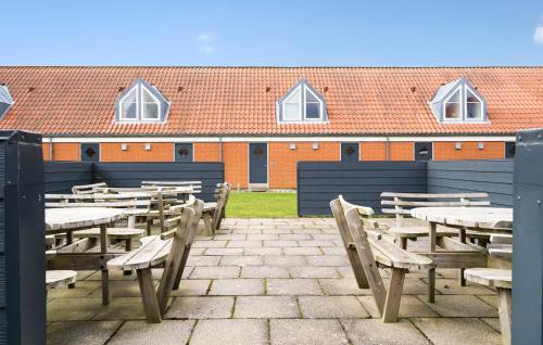a patio with wooden tables and chairs in front of a building at 2 Bedroom Nice Apartment In Lemvig in Lemvig