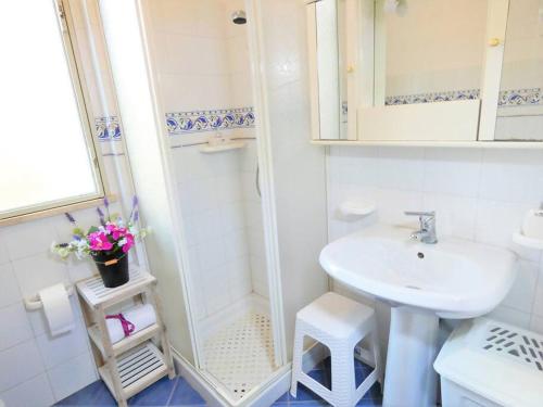 a white bathroom with a sink and a shower at Villa Indipendente Jacuzzi Giardino Clima WiFi in Castellammare del Golfo