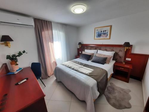 a hotel room with a bed and a desk and a bed at Apartment D&D in Opatija