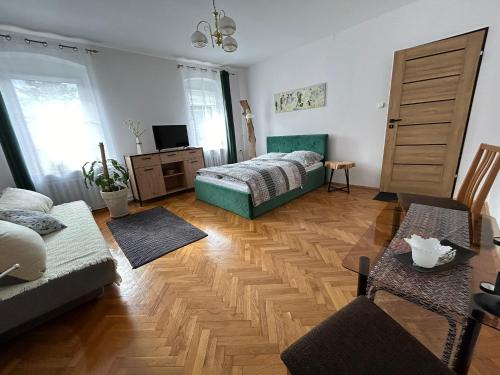 a living room with a bed and a wooden floor at ARTHOME in Wrocław
