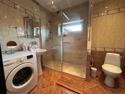 a bathroom with a shower and a washing machine at ARTHOME in Wrocław