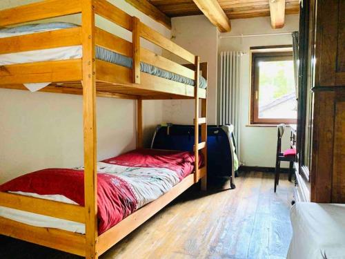 a bedroom with two bunk beds and a window at Baita Gran Bosco: appartamento per 6 persone in Monfol