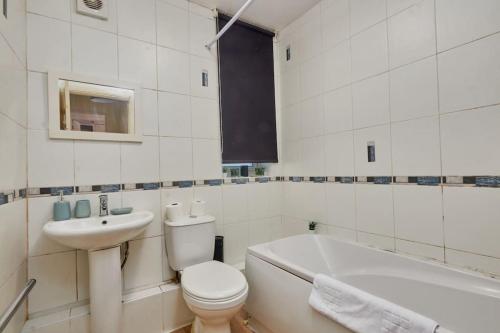 een witte badkamer met een toilet en een wastafel bij Cosy Corner on Burton Road in Derby