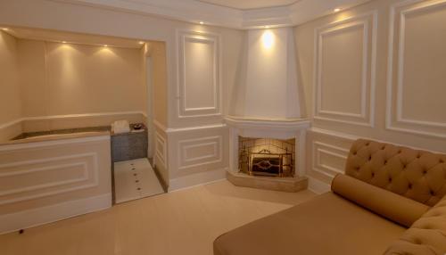 a living room with a couch and a fireplace at Lizon Curitiba Hotel in Curitiba