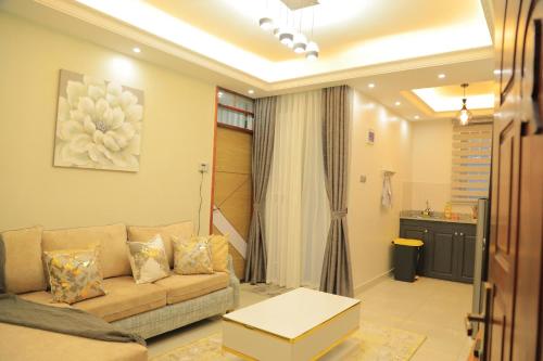 een woonkamer met een bank en een tafel bij Gail Homes Naalya - One bedroom luxury apartment in Kampala