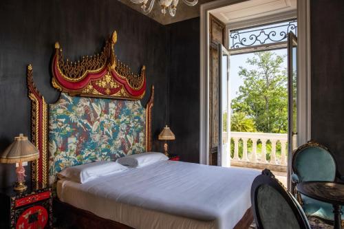 a bedroom with a large bed and a window at Villa De Cillis Carafa in Torre del Greco