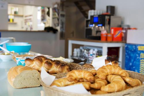 a basket of bread and pastries on a table at Mountain Lodge Backpackercamp in Lenk
