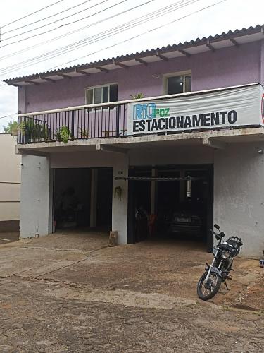 Rio foz camping para motorhome في فوز دو إيغواسو: دراجة نارية متوقفة أمام المبنى