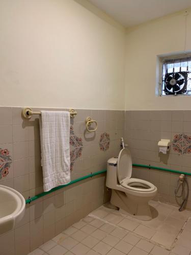 a bathroom with a toilet and a sink at Sunrise Rest House in Islamabad