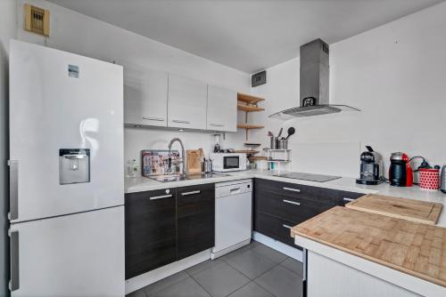 cocina con electrodomésticos blancos y nevera blanca en Room in Appartment with seaview, en Marsella