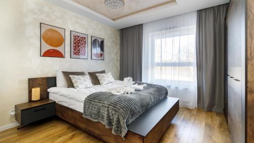 a bedroom with a large bed and a window at Comfy Apartments - Morska Bryza in Gdańsk