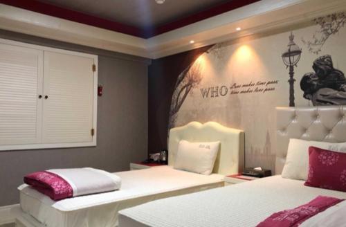 a bedroom with two beds and a sign on the wall at Jara Changwon in Changwon