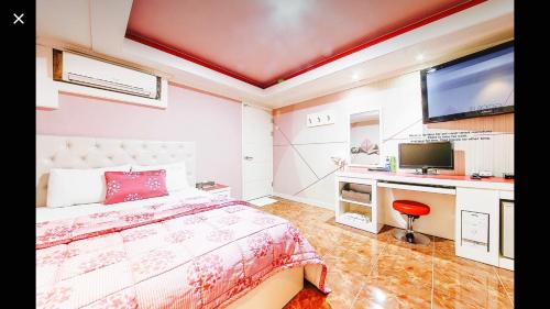 a bedroom with a bed and a flat screen tv at Jara Changwon in Changwon
