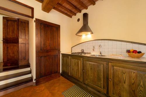 古比奧的住宿－Fonte Chiara，一个带木制橱柜和水槽的厨房