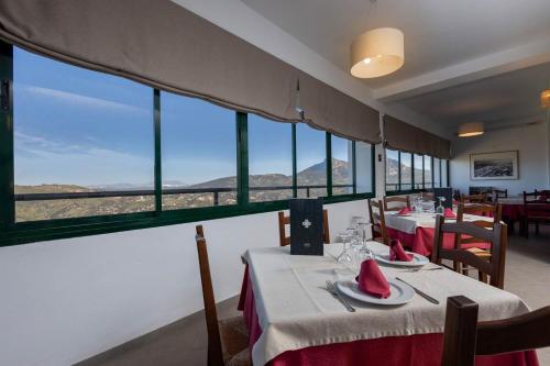 um restaurante com mesas e cadeiras com vista em Hotel Tugasa Arco de la Villa em Zahara de la Sierra