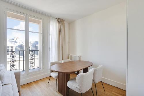 une salle à manger avec une table et des chaises et une fenêtre dans l'établissement Pick A Flat's Apartment in Saint Michel - Rue Du Sommerard, à Paris