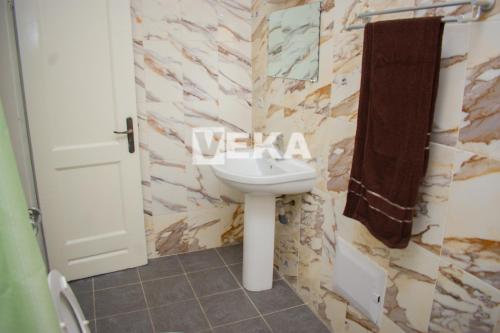 a bathroom with a sink and a towel at Studio Le Parisien in Pointe-Noire