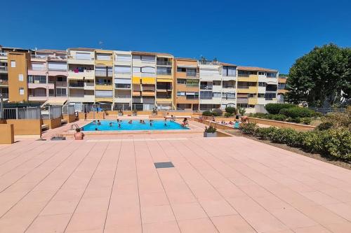 une grande piscine devant un immeuble dans l'établissement Cap sur le port, au Cap d'Agde