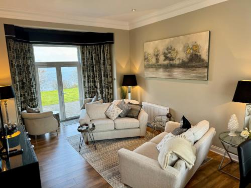 Sala de estar con 2 sofás y mesa en Loch View at Lomond Castle, en Balloch