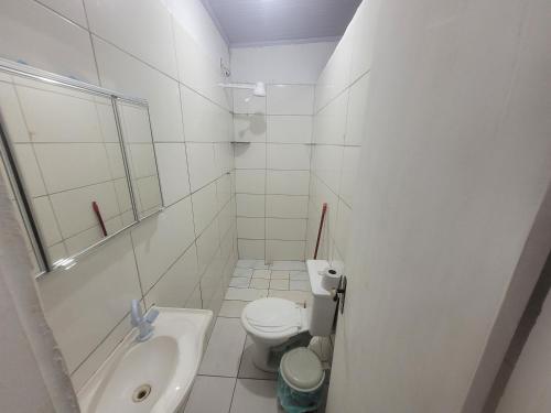 a white bathroom with a toilet and a sink at Hospedaria cmc unidade 02 in Riacho Fundo