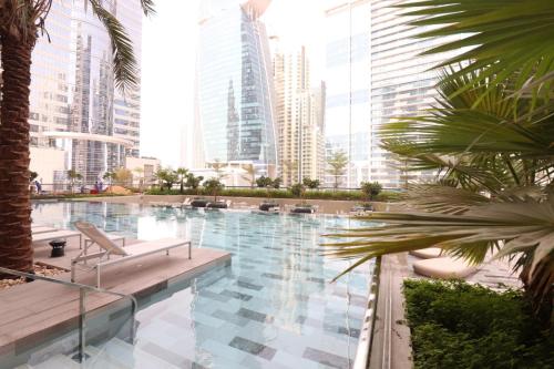 a swimming pool in a city with tall buildings at Pool View One Bed Room Business Bay in Dubai