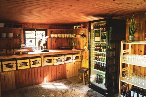 a kitchen with wooden walls and a refrigerator with wine bottles at Boomkamp treehouses in Oostkamp