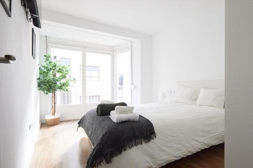 1 dormitorio blanco con 1 cama grande con manta negra en Low Cost Apartments Center Elche, en Elche