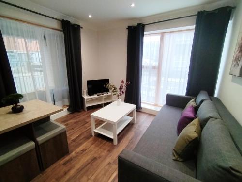 uma sala de estar com um sofá e uma televisão em Luxury apartment near London centre, near train station, E1 em Londres