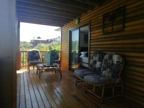 een veranda met 2 stoelen en een glazen schuifdeur bij 44 Nature On Sea in Groot Brak Rivier