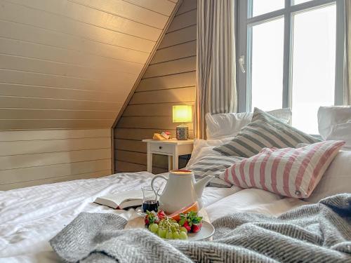a white bed with a plate of fruit on it at traumHaff Lotsen Romantik-Ostsee mit Kamin, privates NORDICSPA und Boot in Rieth