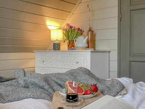 a table with a bowl of fruit on a bed at traumHaff Lotsen Romantik-Ostsee mit Kamin, privates NORDICSPA und Boot in Rieth