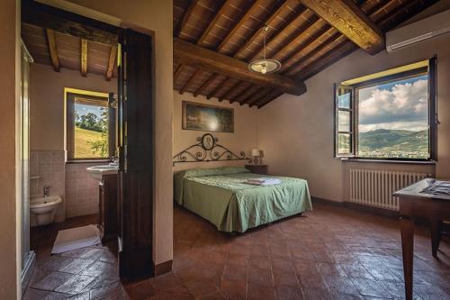 una camera con un letto e un lavandino e due finestre di Fonte Chiara a Gubbio