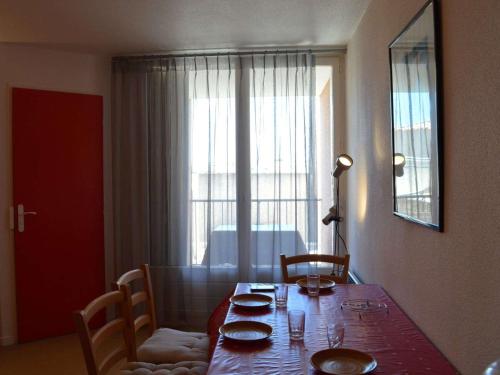 d'une table à manger avec des assiettes et une fenêtre. dans l'établissement Appartement T2 à Saint Pierre la Mer, proche plage, loggia sud, parking, animaux acceptés - FR-1-229D-272, à Saint Pierre La Mer