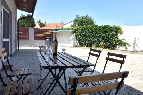 a wooden table with a bottle of wine and chairs at Apartmán Hrušky in Hrušky