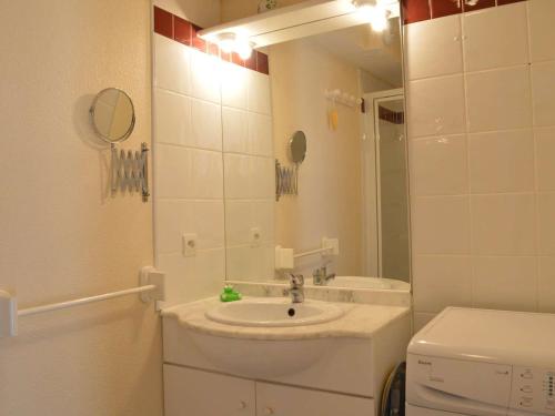 une salle de bain avec un lavabo et un miroir et des toilettes dans l'établissement Pavillon climatisé 2 pièces mezzanine, terrasse, parking, 900m plage – Saint-Pierre-la-Mer - FR-1-229D-65, à Fleury