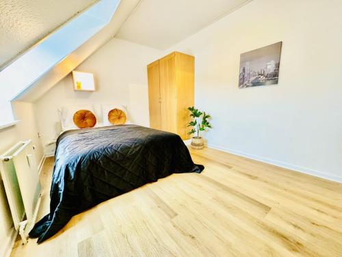 a bedroom with a bed and a wooden floor at aday - Stylish Central Apartment in Hjorring in Hjørring